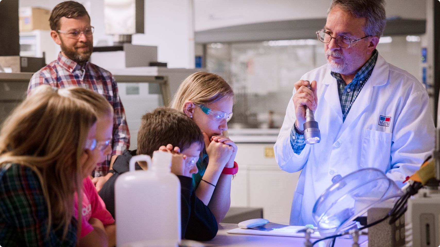 Hill's Pet Nutrition Center researcher showing the pet food lab to a group of kids